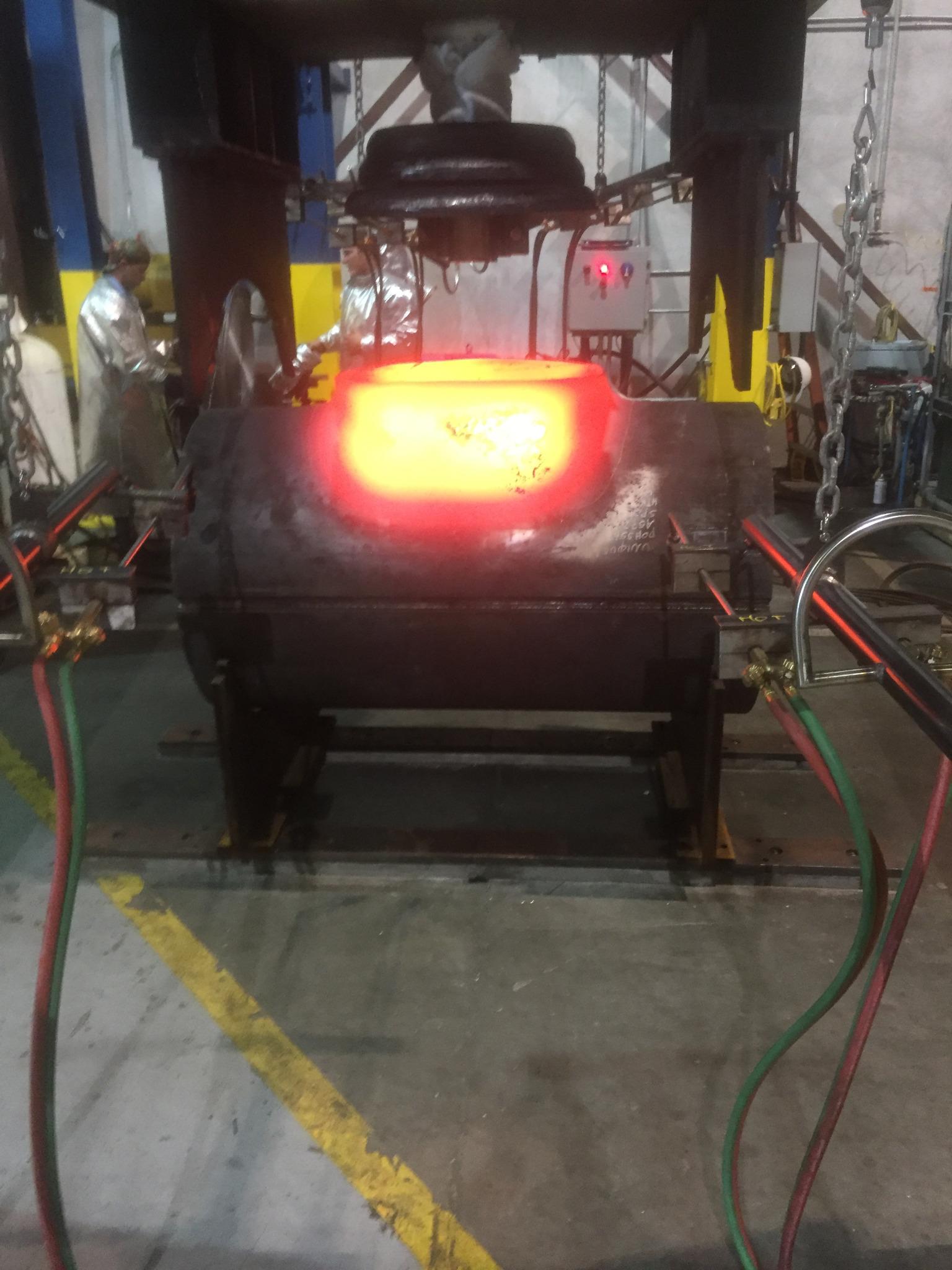 Larger die drawing a yellow-hot branch through progressive tooling