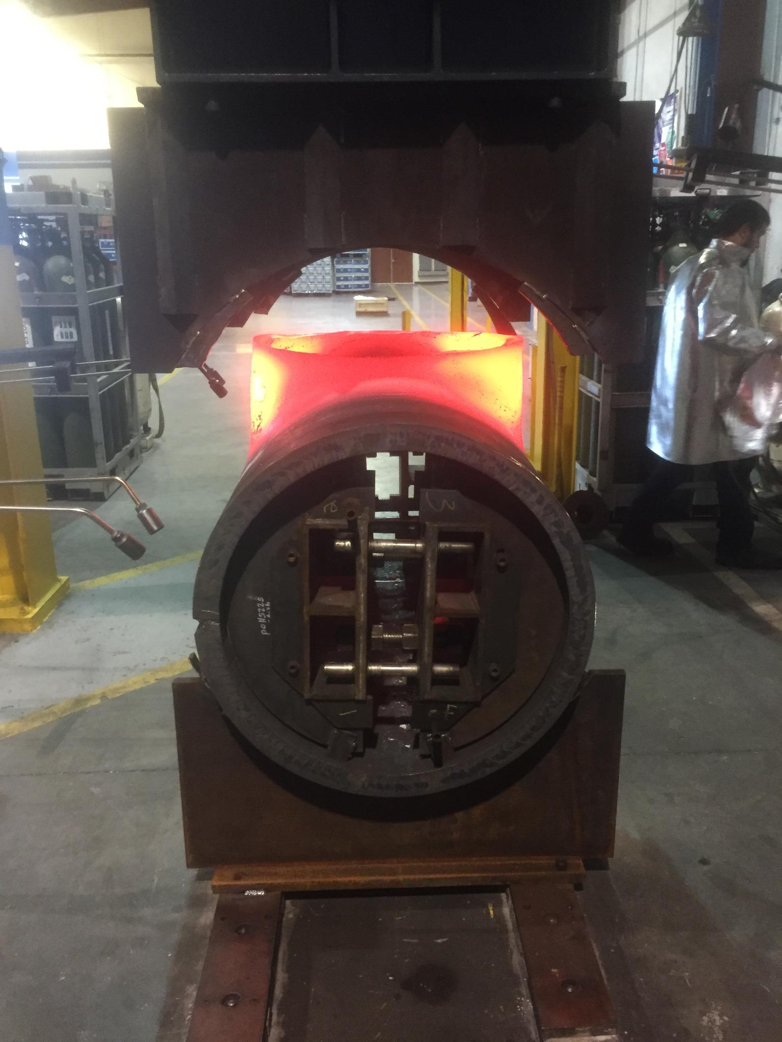 Heavy-wall fitting glowing during hot forming inside a large press